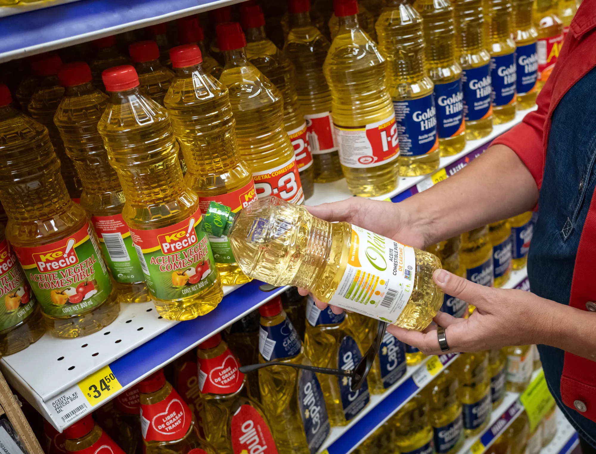 Shopper browsing packaged food products on a grocery store shelf in an international market.