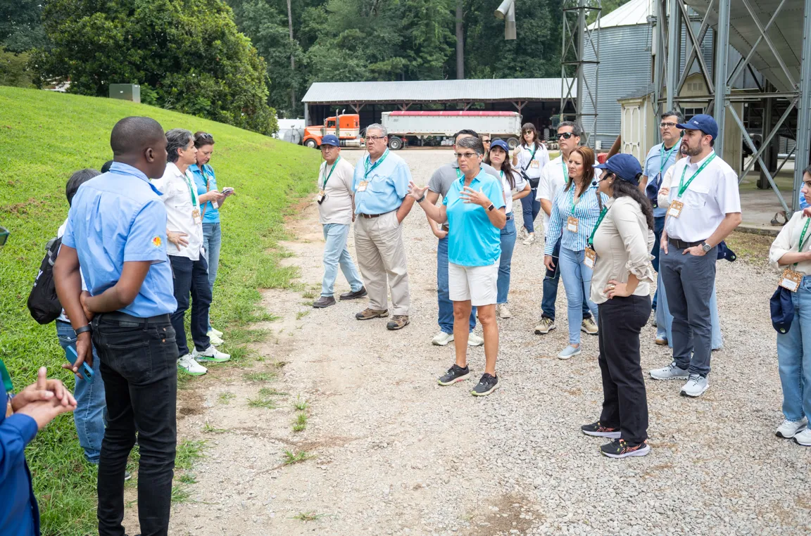 Group of people listen to a speaker while touring a grain storage facility.