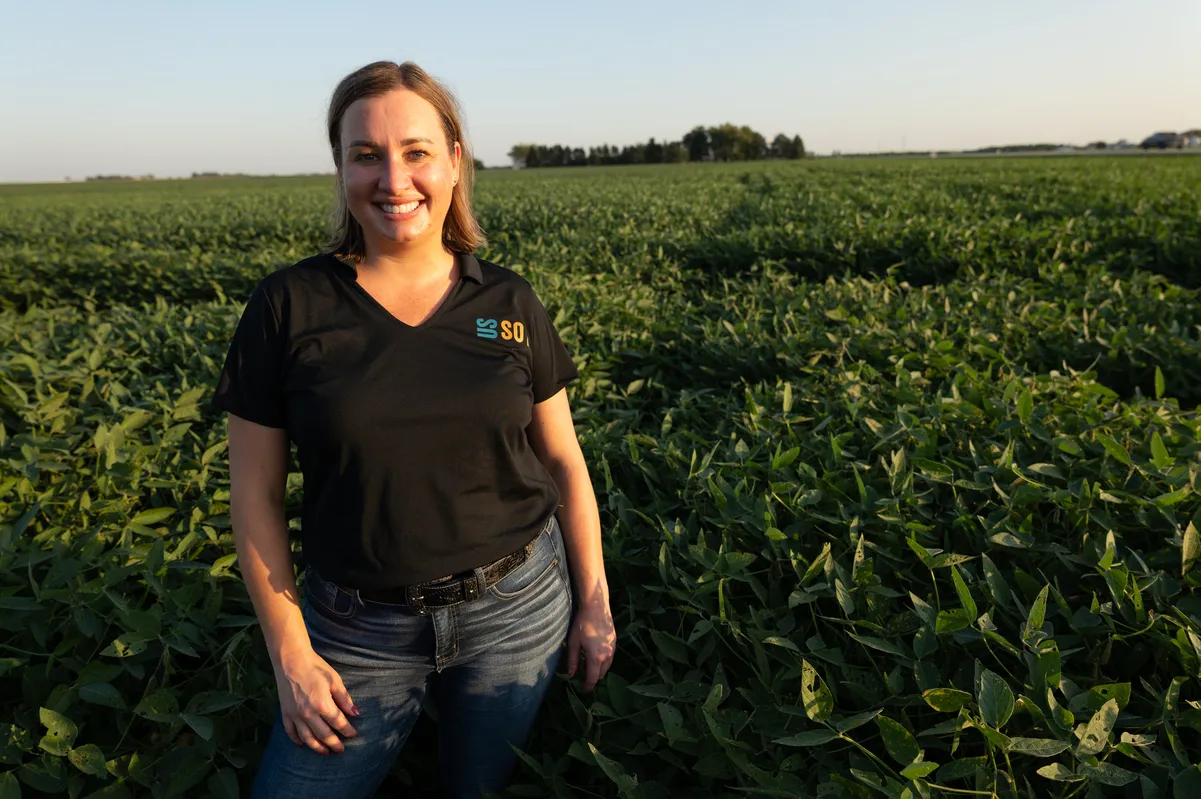 United Soybean Board CEO Courtney Knupp stands in a green field.