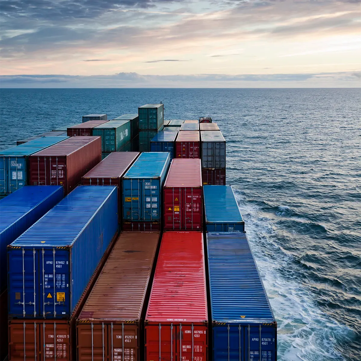 A large, maritime cargo ship moves steadily across open ocean waters.