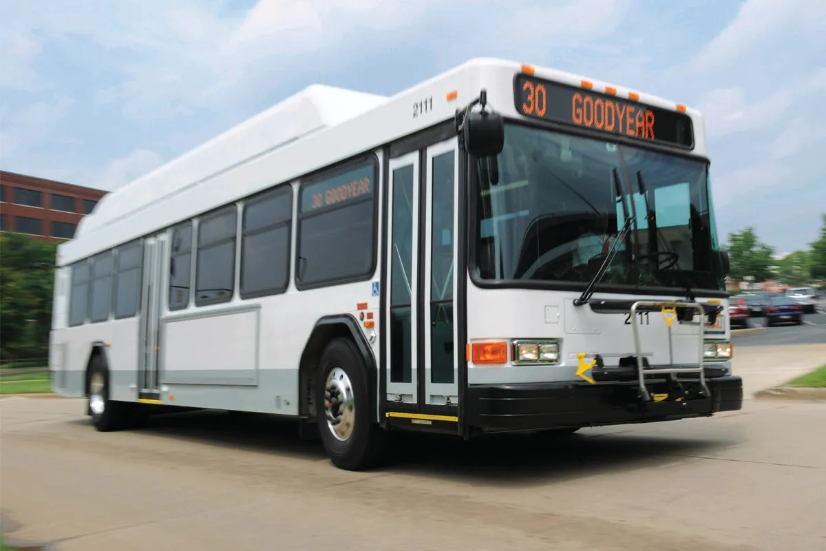 Public transit bus traveling on a city street with a route display reading “30 Goodyear.”