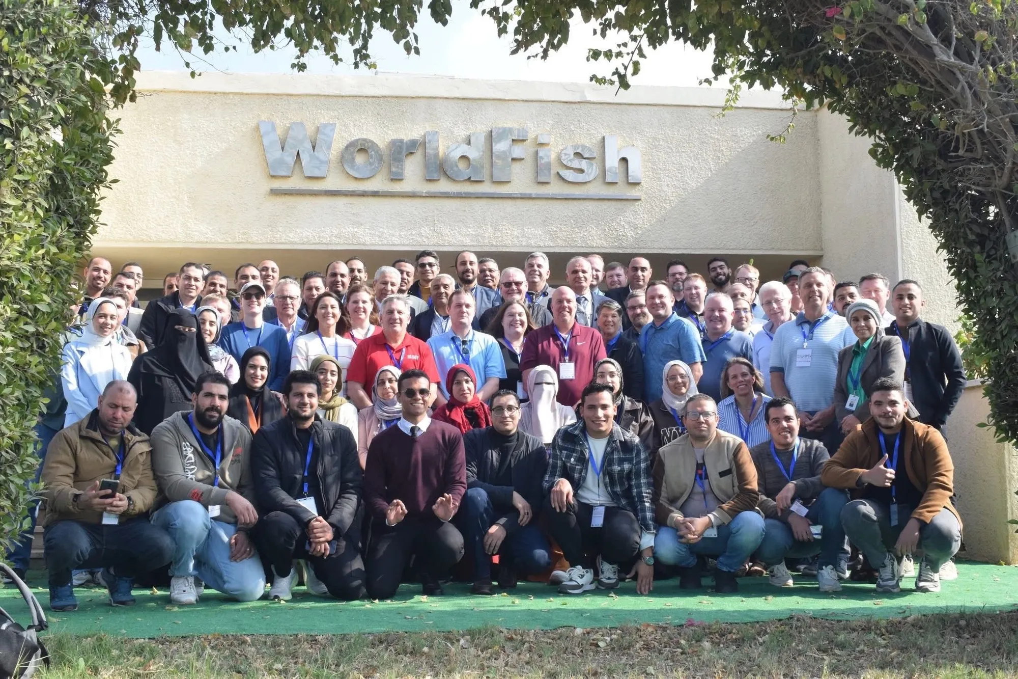 Group of people posing together outside a WorldFish building.