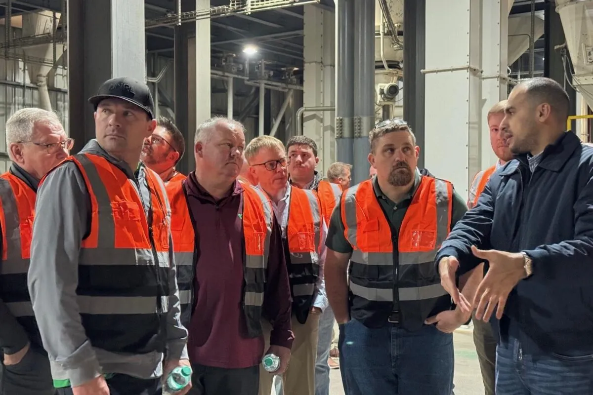 Group of people wearing safety vests listening to a guide during a facility tour in Egypt.