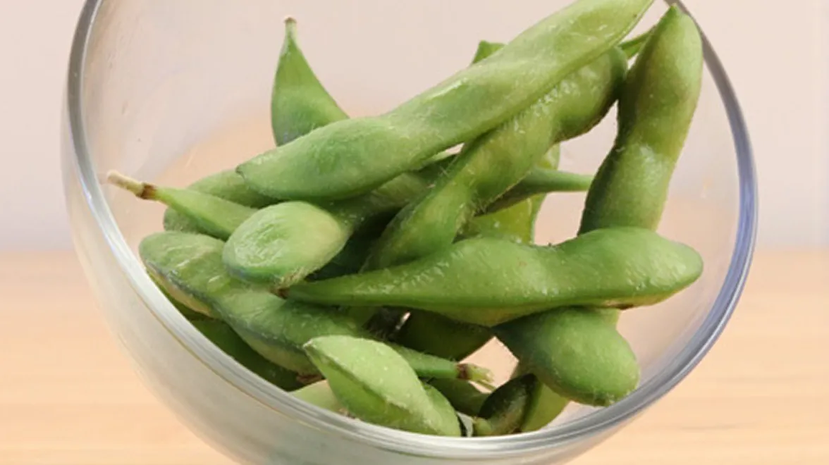 Bowl of fresh edamame pods, a soy-based food product.