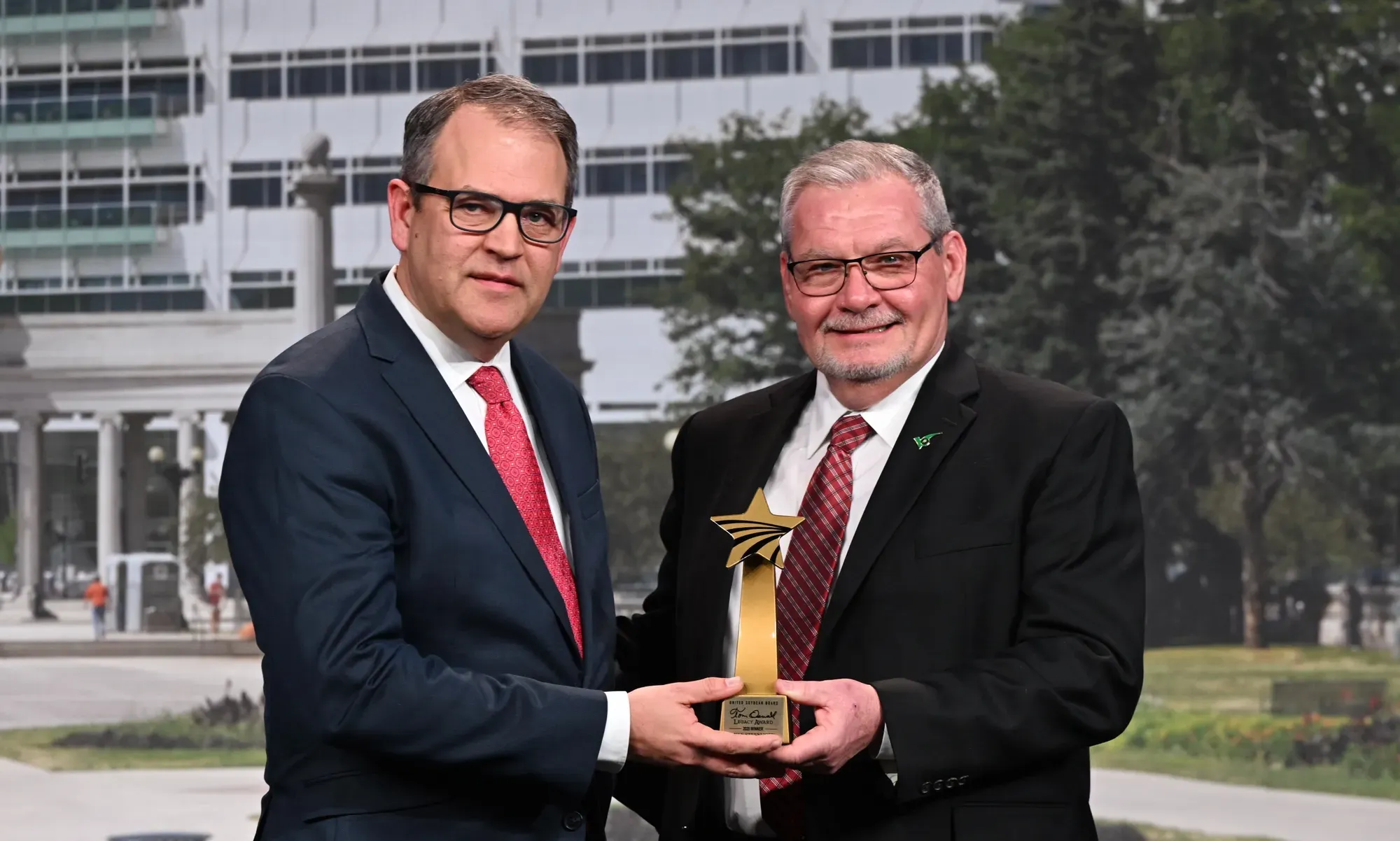 Mike Steenhoek accepts the 2025 Tom Oswald Legacy Award alongside a United Soybean Board representative.