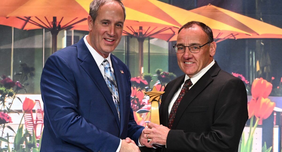 United Soybean Board Chair Steve Reinhard presents Ed Anderson with the 2024 Tom Oswald Legacy Award.
