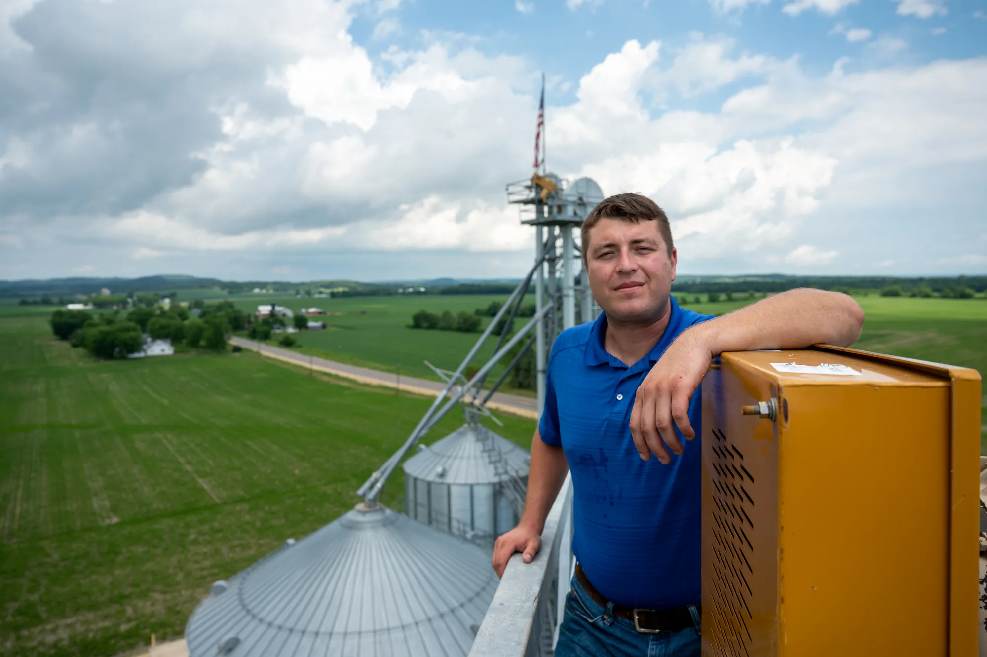 Wisconsin farmer standing above grain bins overlooking soybean operation.