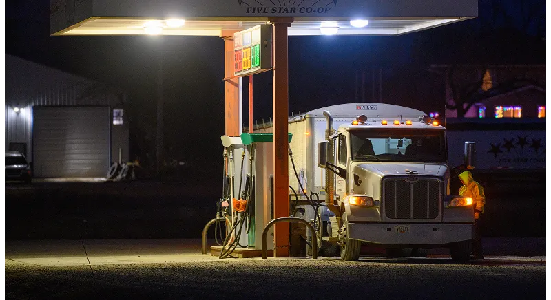 Commercial semi-trucks on a highway using soy-based renewable diesel as a drop-in fuel.
