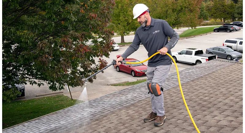Worker applying a roof coating, representing soy-based materials used in residential and commercial construction products.