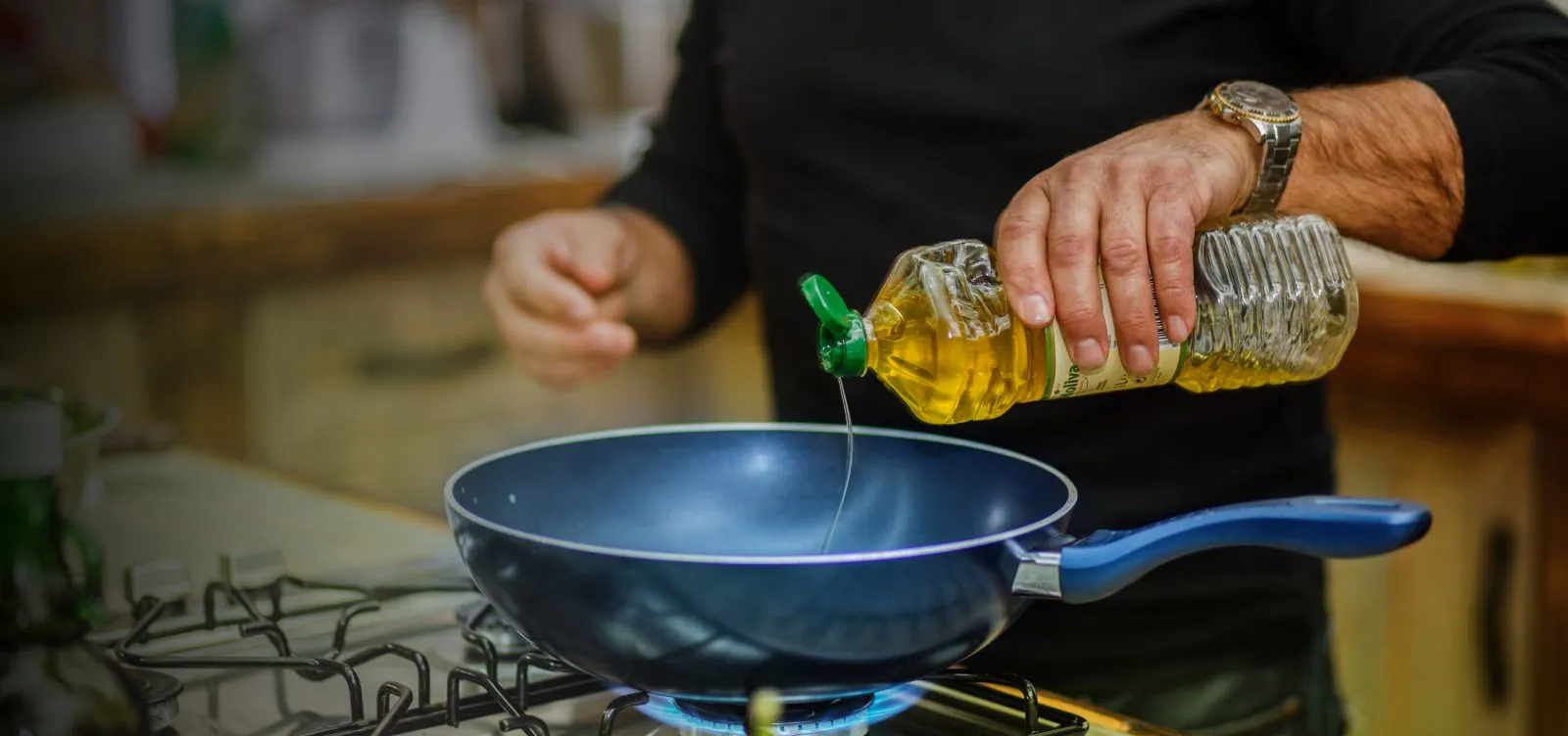 Person pouring soybean oil into a pan. 